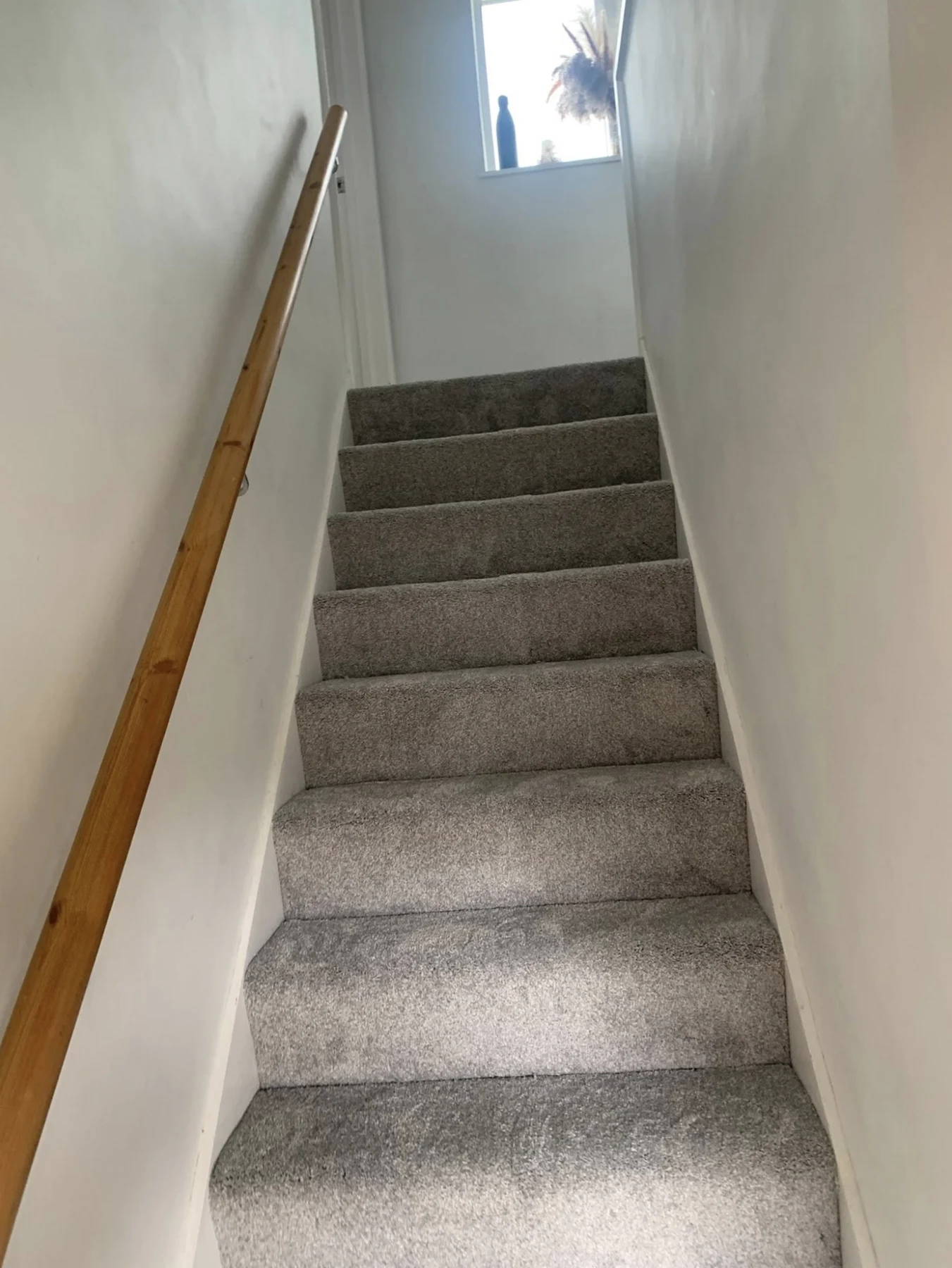 Neatly fitted grey carpet covering a staircase