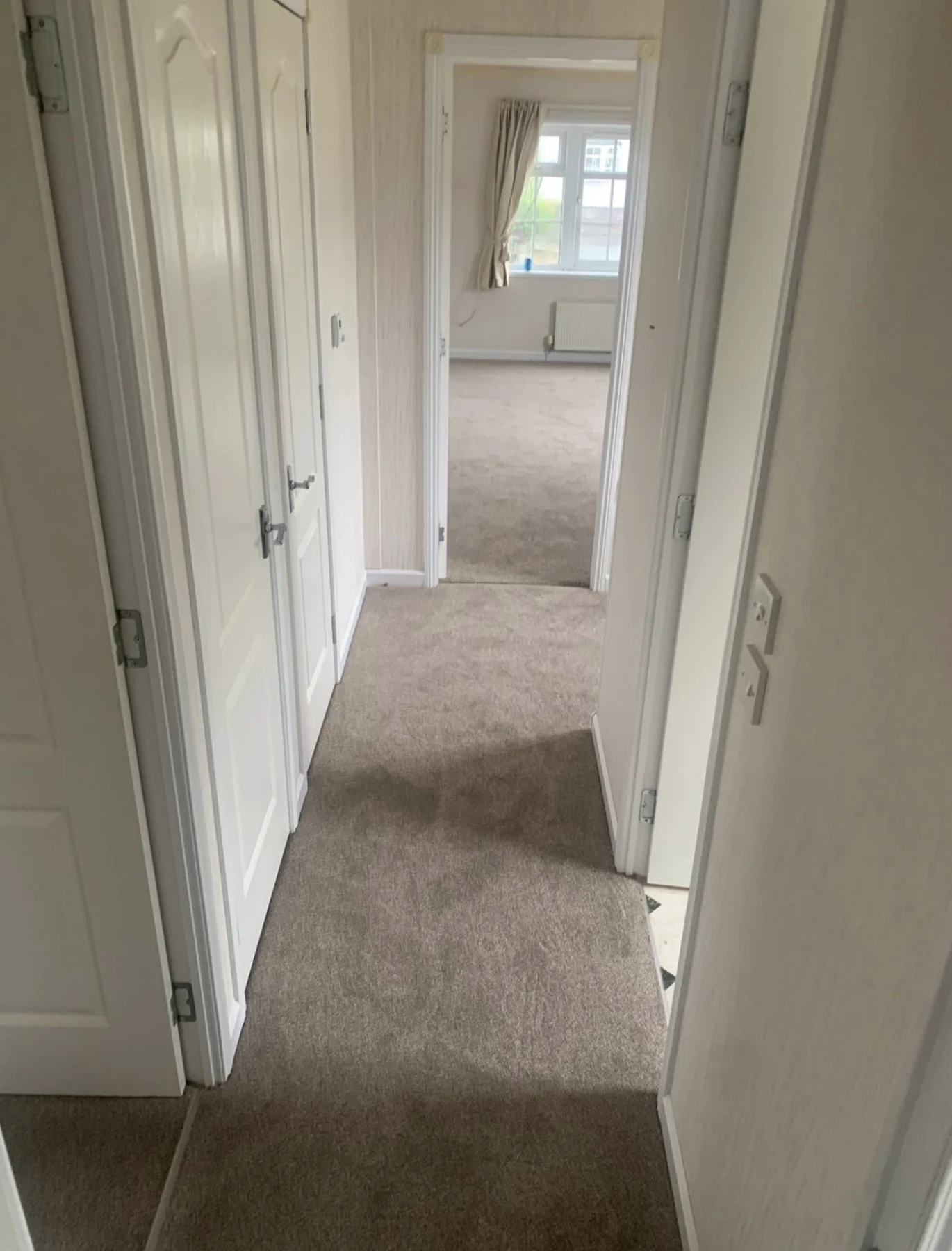 Carpet flooring leading through a home corridor