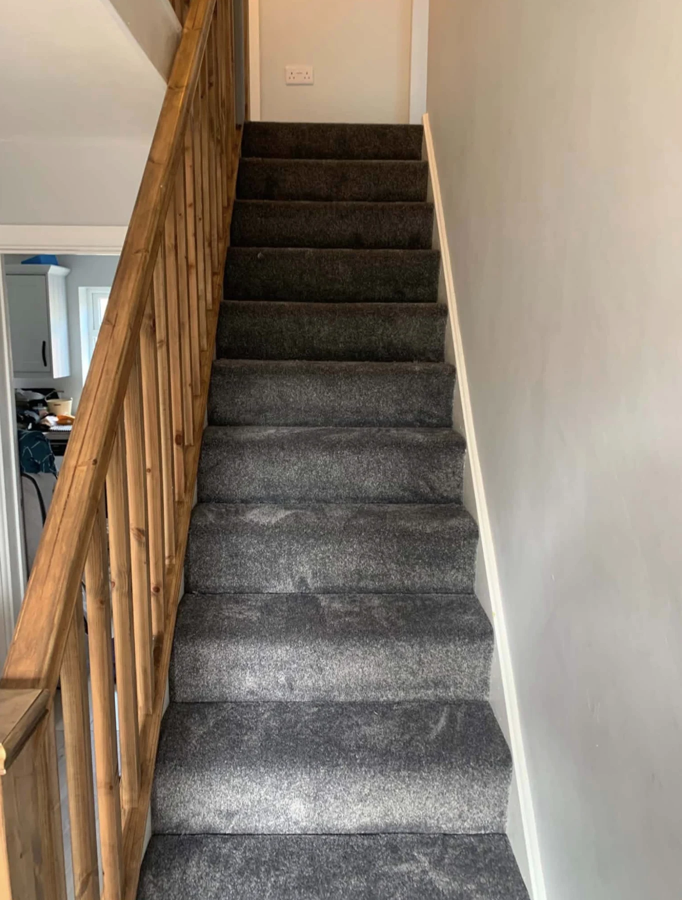 Dark grey carpet fitted neatly to a staircase