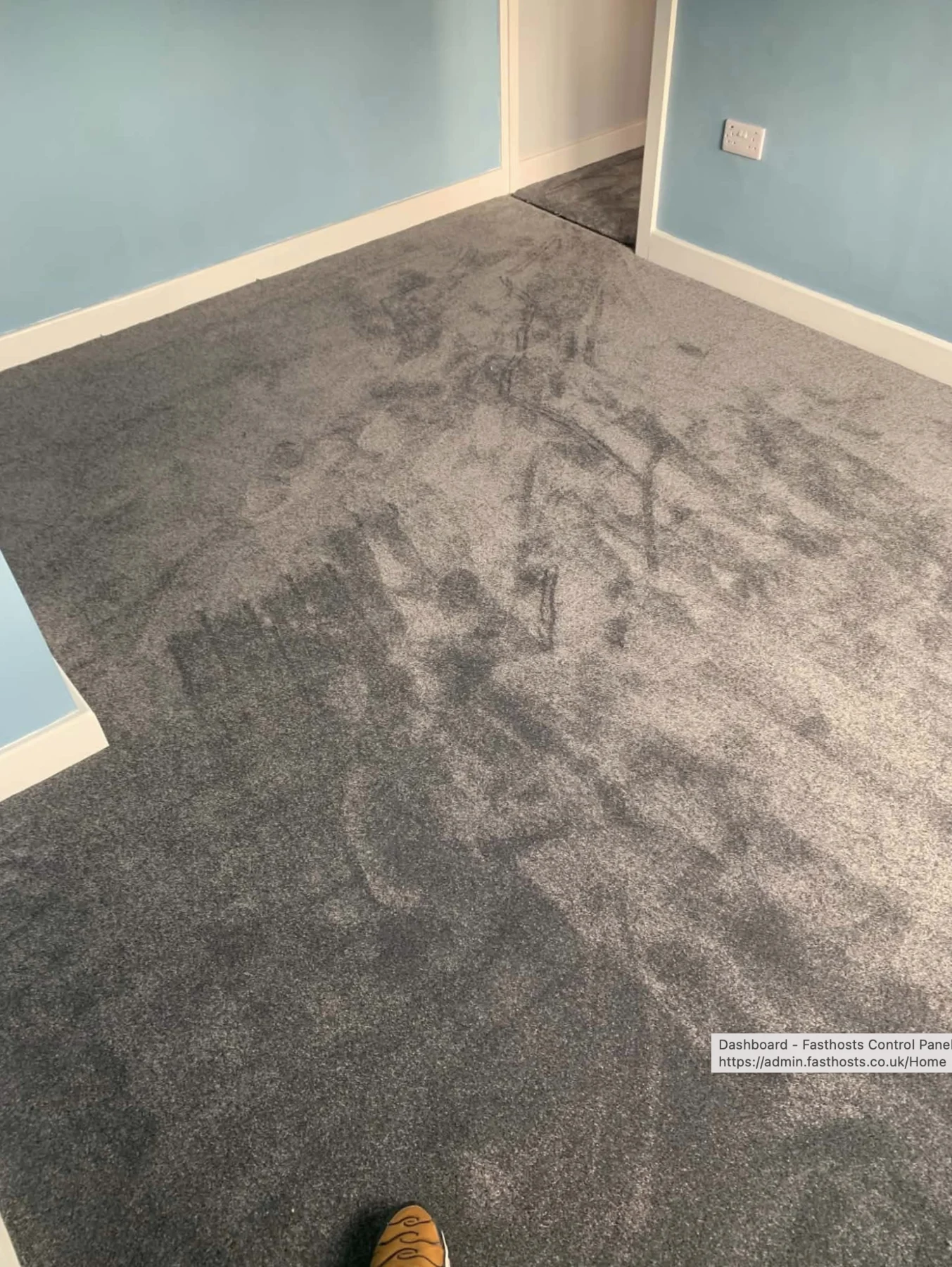 Textured grey carpet fitted in a room with pale blue walls