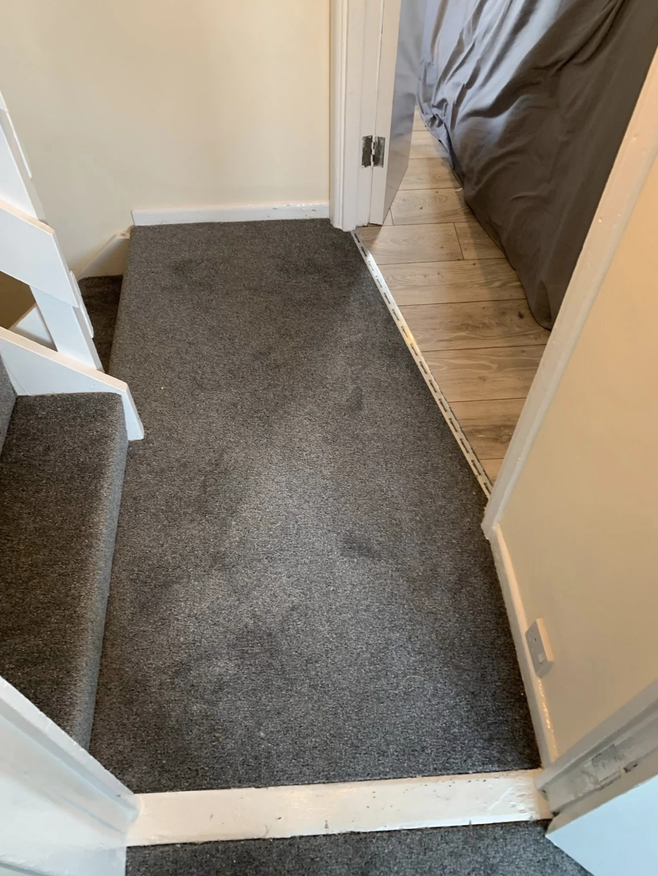 Carpet fitted through a hallway beside a wood-effect floor